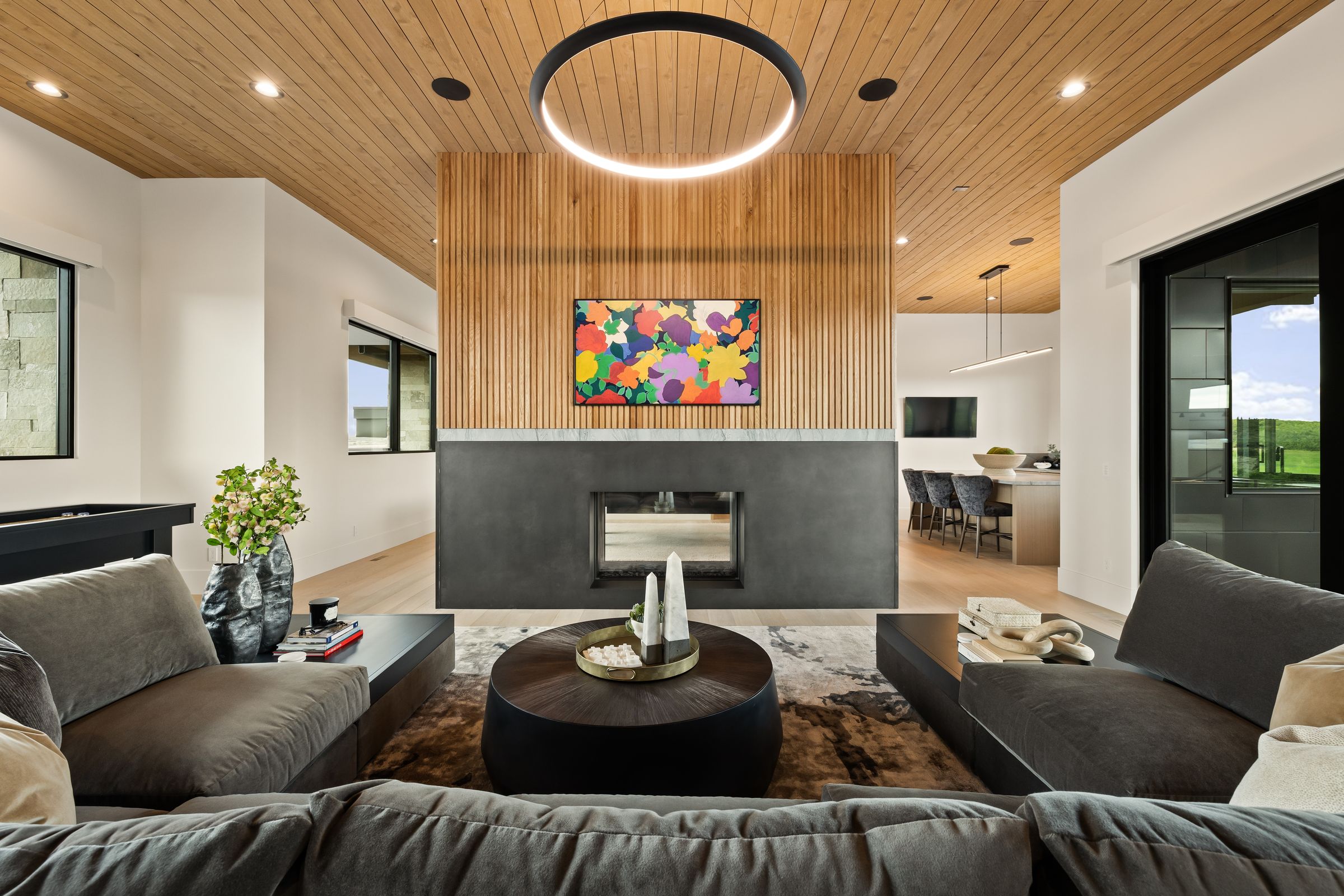 Great room with a double-sided fireplace and walnut slat ceiling