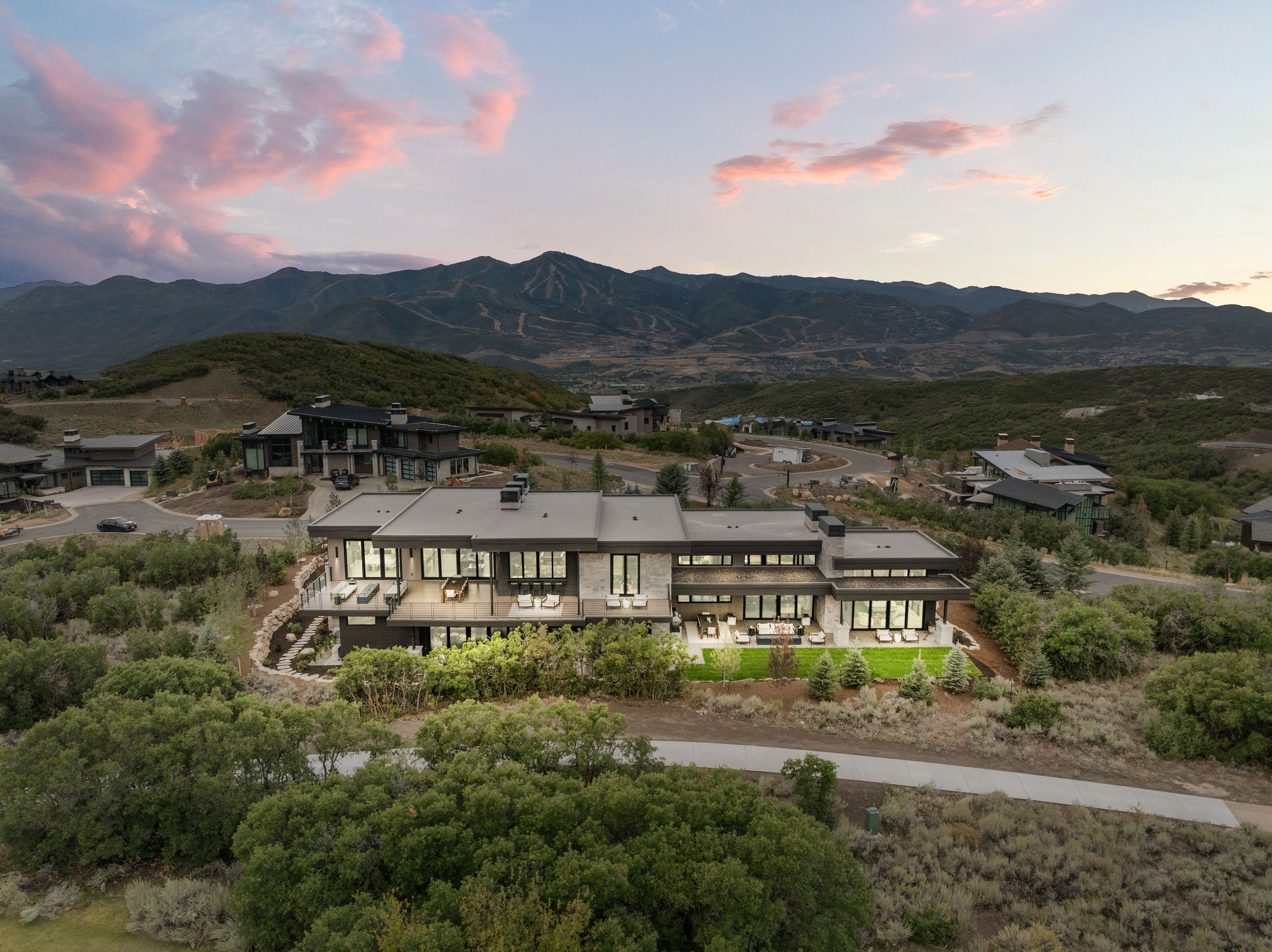 Rear elevation and terraced lawn of 2155 Adventure Way against the mountains