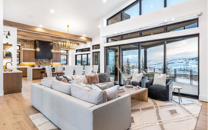 Open living room with floor-to-ceiling glass and valley views