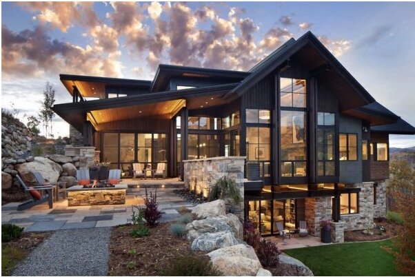 Mountain residence with timber rooflines, stone walls, and landscaped outdoor living areas